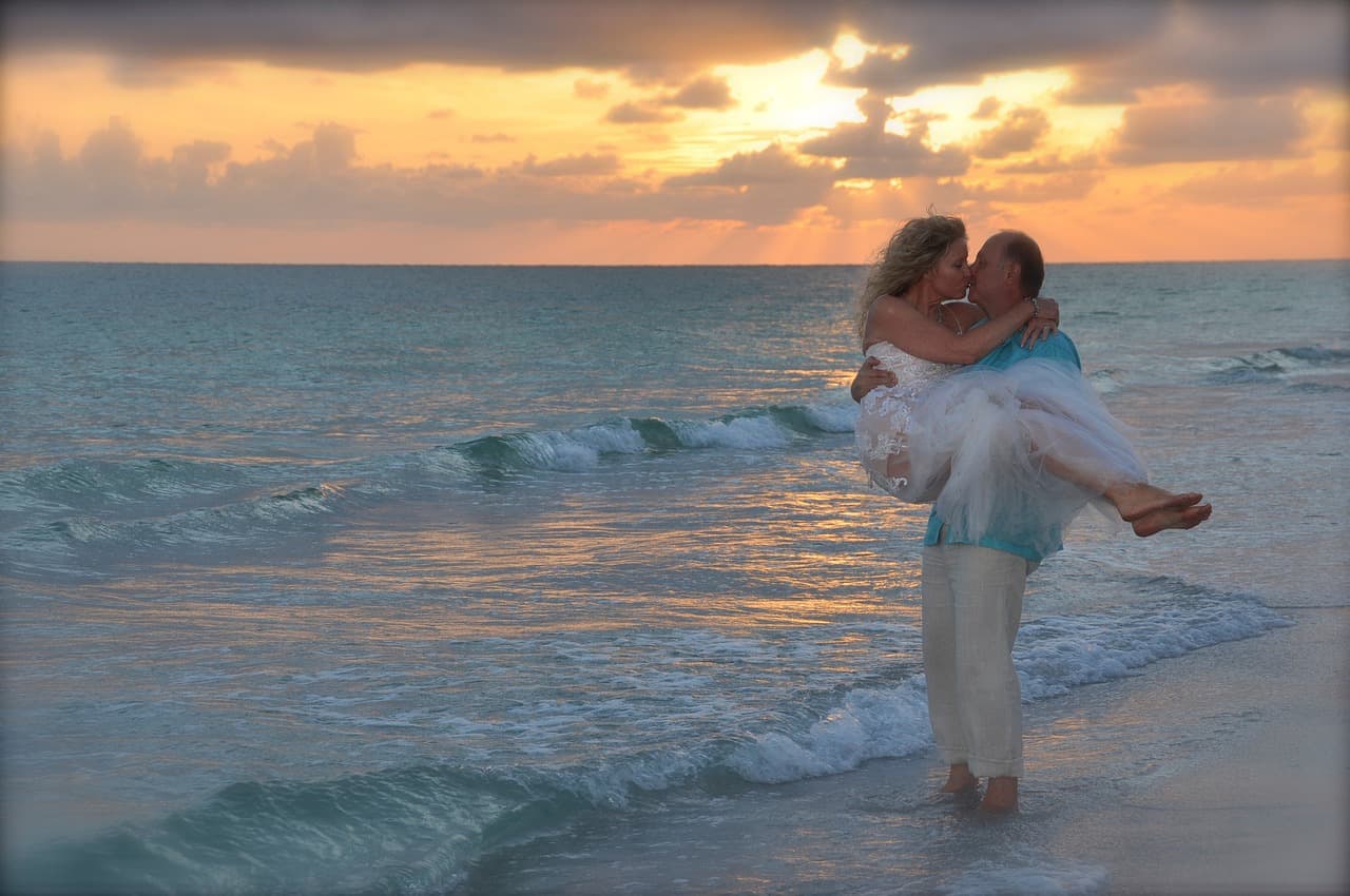 A couple embracing closely, the kind of moment that often inspires an anniversary or wedding song